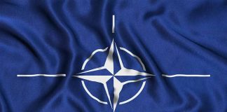 NATO flag with blue background and white compass.