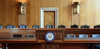 Empty U.S. Senate hearing room with wooden furniture.