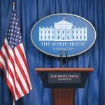 White House podium with American flag and seal.