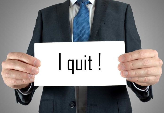 Person holding a sign saying "I quit!"