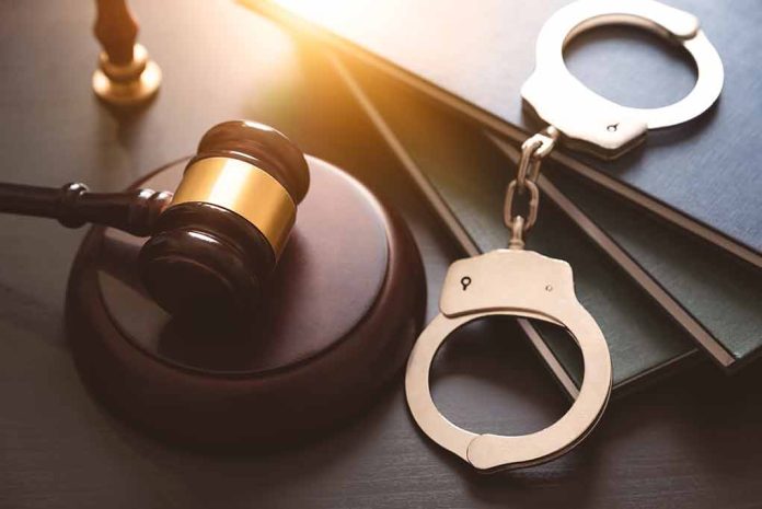 Gavel, books, and handcuffs on a table.