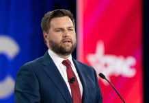 Man in suit speaking at conference podium