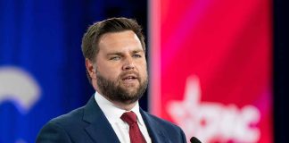 Man in suit speaking at conference podium