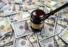 Gavel on pile of hundred dollar bills