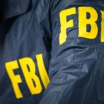 FBI agent wearing a jacket with yellow letters.