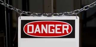 Danger sign hanging on metal chain.