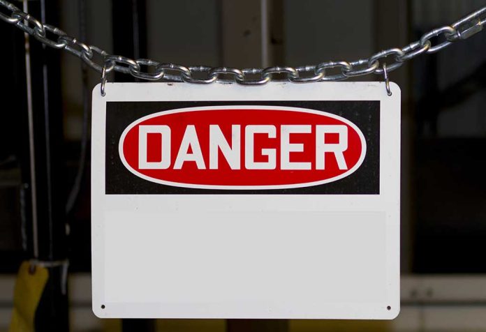 Danger sign hanging on metal chain.