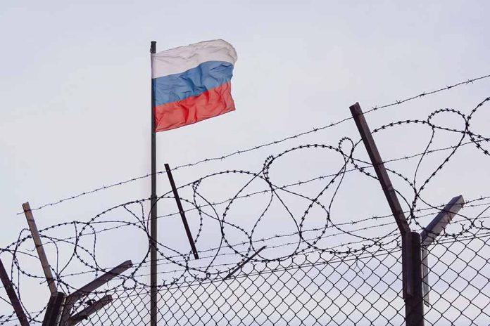 Russian flag behind barbed wire fence skyward view