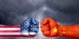 Two fists with American and Chinese flags opposing