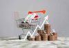 Shopping cart with coins and upward trend arrow
