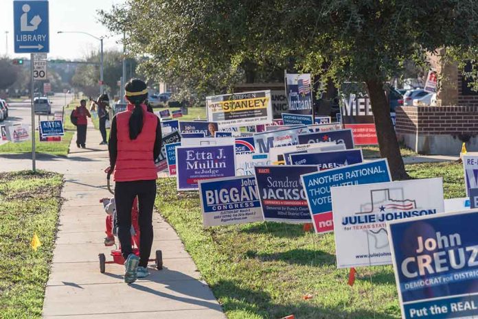 1039327252 featured image Person walking with stroller past numerous election campaign signs.