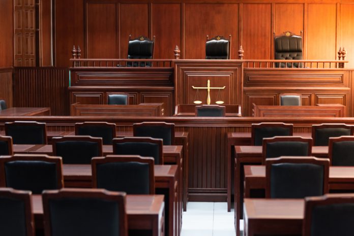 1324425602 featured image Empty courtroom with wooden furniture and chairs
