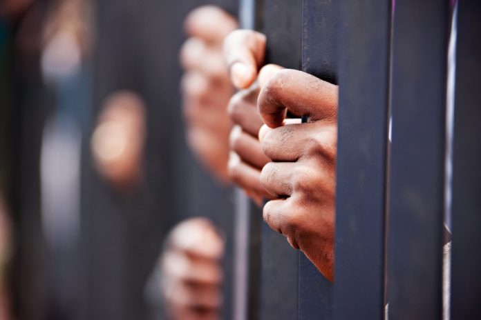 Hands gripping metal bars in focus