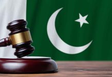 Gavel with Pakistan flag in the background.