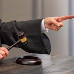 Judge pointing and holding gavel in hand