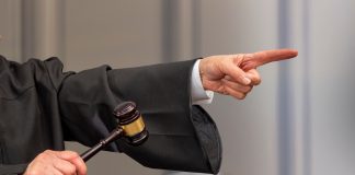 Judge pointing and holding gavel in hand