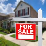 For sale sign in front of house