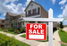 For sale sign in front of house