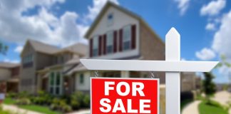 For sale sign in front of house