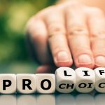 Hand flipping dice spelling pro life choice