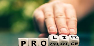 Hand flipping dice spelling pro life choice