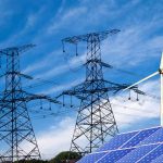 Power lines solar panels and wind turbine against sky