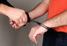 Person being handcuffed wearing orange shirt jeans