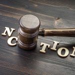 Gavel on table with letters spelling sanctions