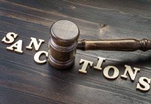 Gavel on table with letters spelling sanctions