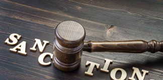 Gavel on table with letters spelling sanctions