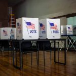 Voting booths with American flag and vote sign