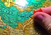 Hand placing pin on map of Afghanistan