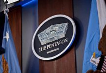 The Pentagon emblem between two flags