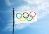 Olympic flag waving against a blue sky