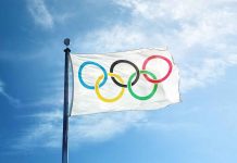 Olympic flag waving against a blue sky