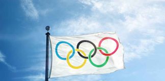 Olympic flag waving against a blue sky