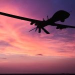 Drone silhouette against vibrant sunset sky