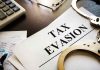 tax evasion document with handcuffs calculator and papers