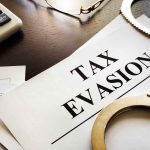 tax evasion document with handcuffs calculator and papers