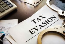 tax evasion document with handcuffs calculator and papers