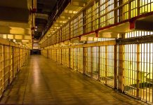 Empty hallway between rows of prison cells