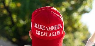 Red Make America Great Again hat on person's head