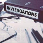 Documents and binder labeled Investigations on desk
