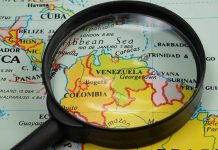 Magnifying glass focusing on Venezuela and Colombia on map