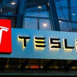 Tesla logo on a building at night.