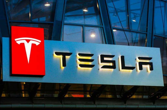 Tesla logo on a building at night.