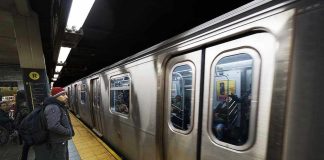 Man waiting at subway platform with departing train