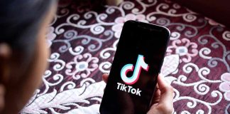 Hand holding phone showing TikTok logo