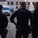 Three police officers standing on a city street
