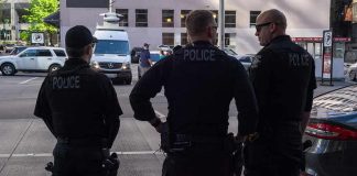 Three police officers standing on a city street